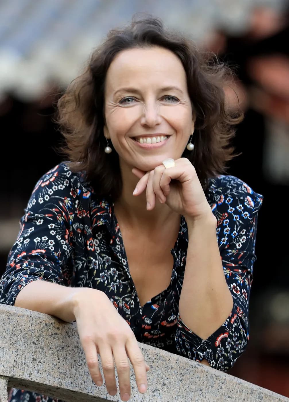 Nicole Mira Simon im Freien, das Kinn auf die Hand gestützt.